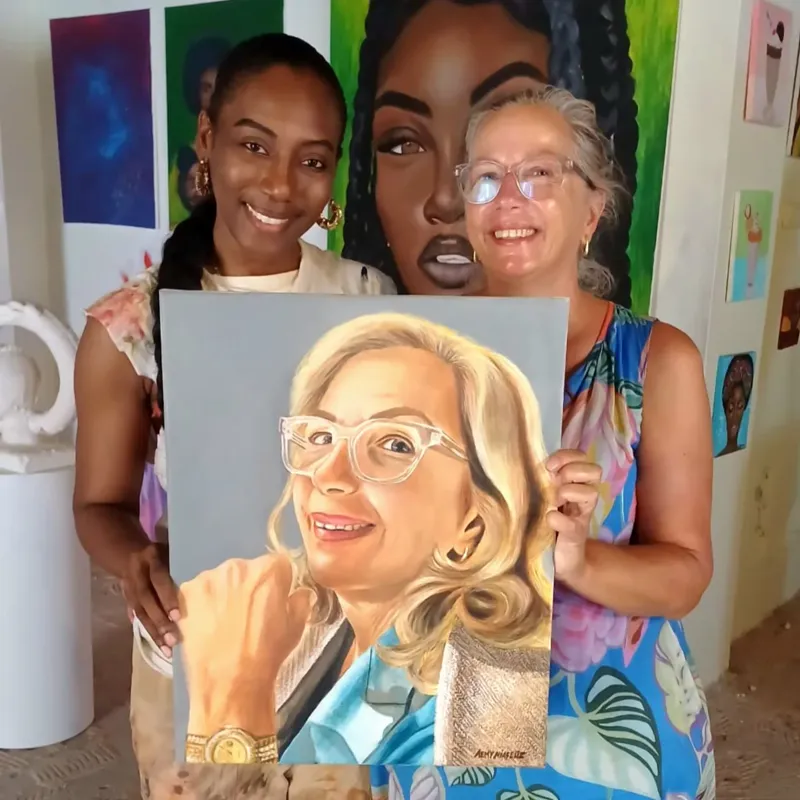 Two women holding a finished portrait