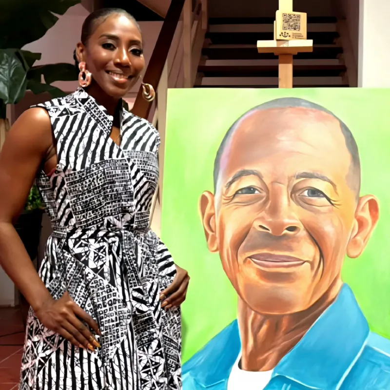 A woman beside a portrait of a smiling man